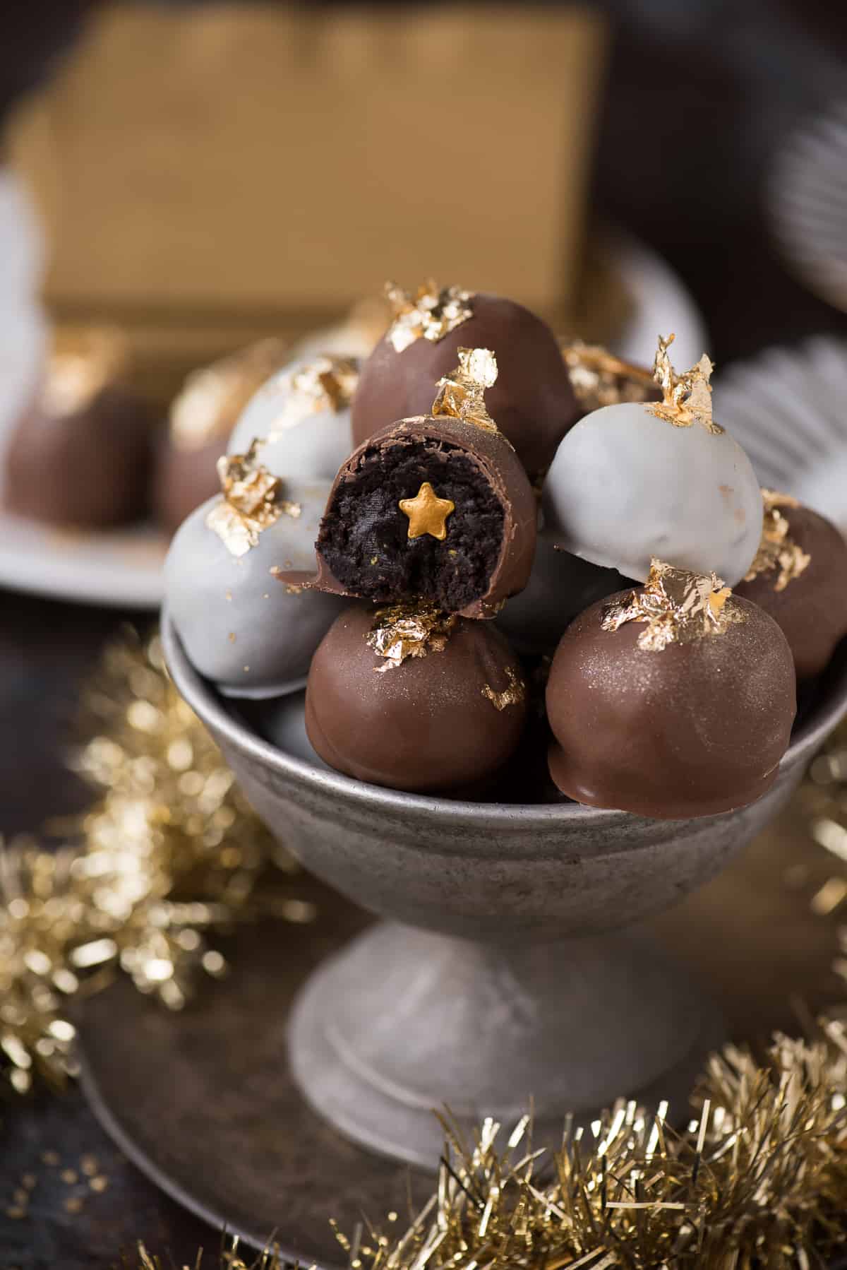 oreo balls displayed in metal bowl with edible gold flakes on top