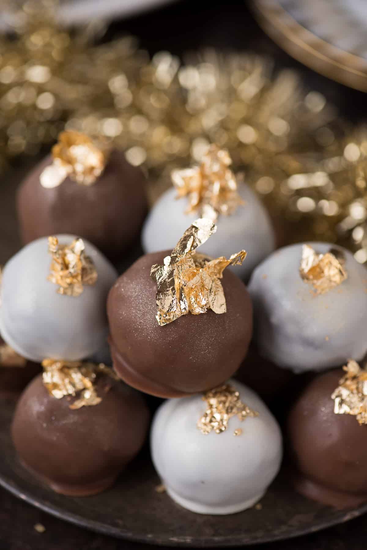 oreo balls displayed in metal bowl with edible gold flakes on top