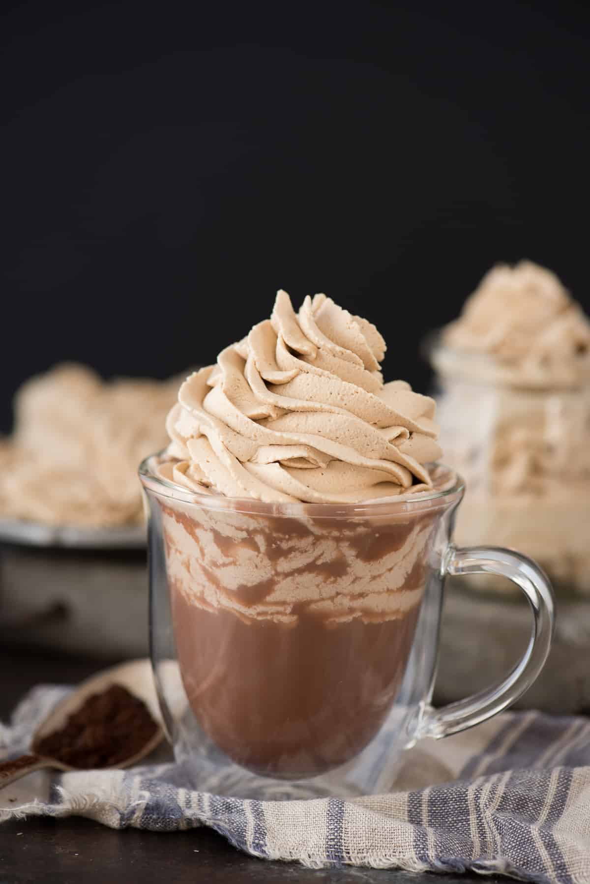 hot chocolate in glass mug with coffee whipped cream on top