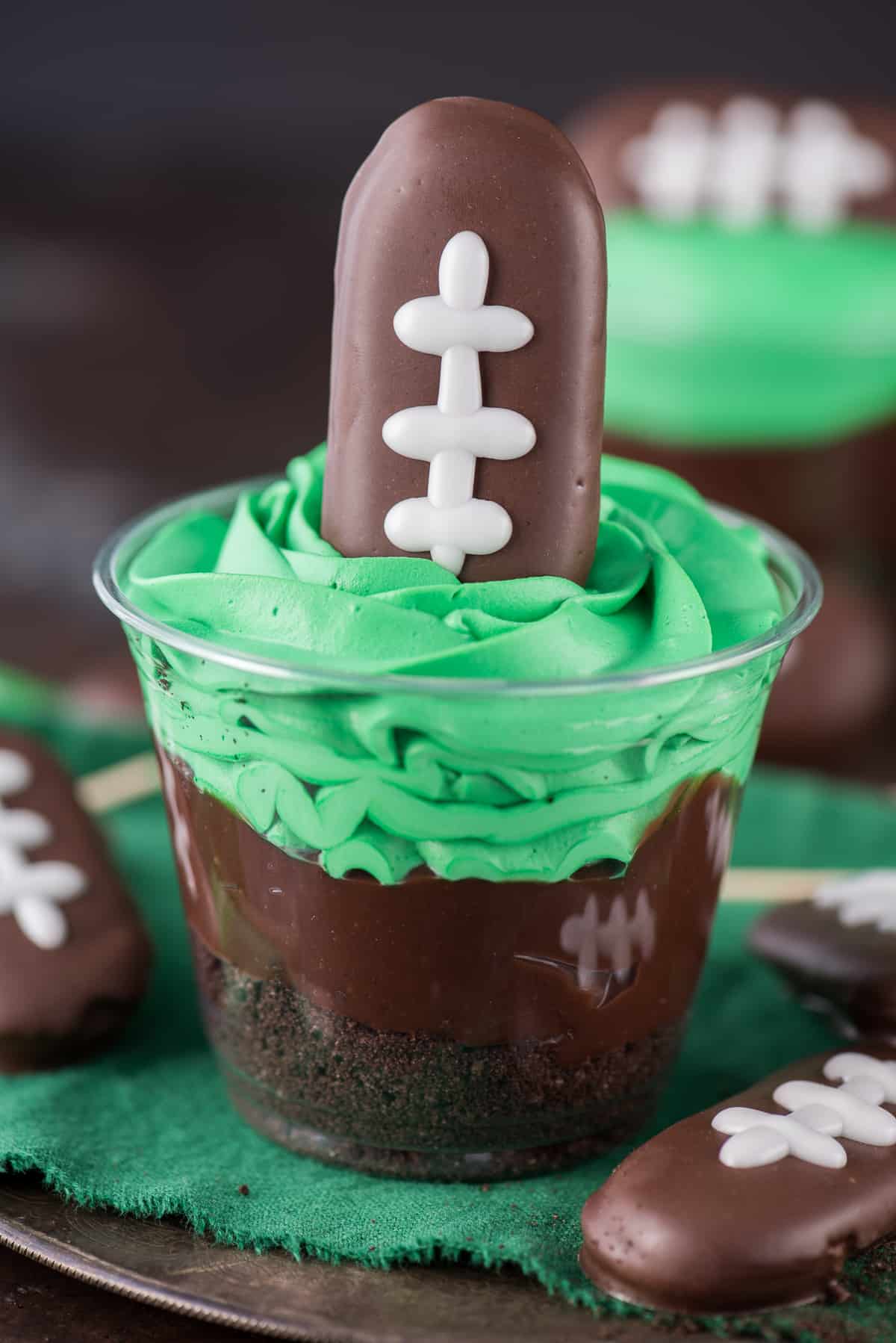 Football cookie on top of football themed cups.