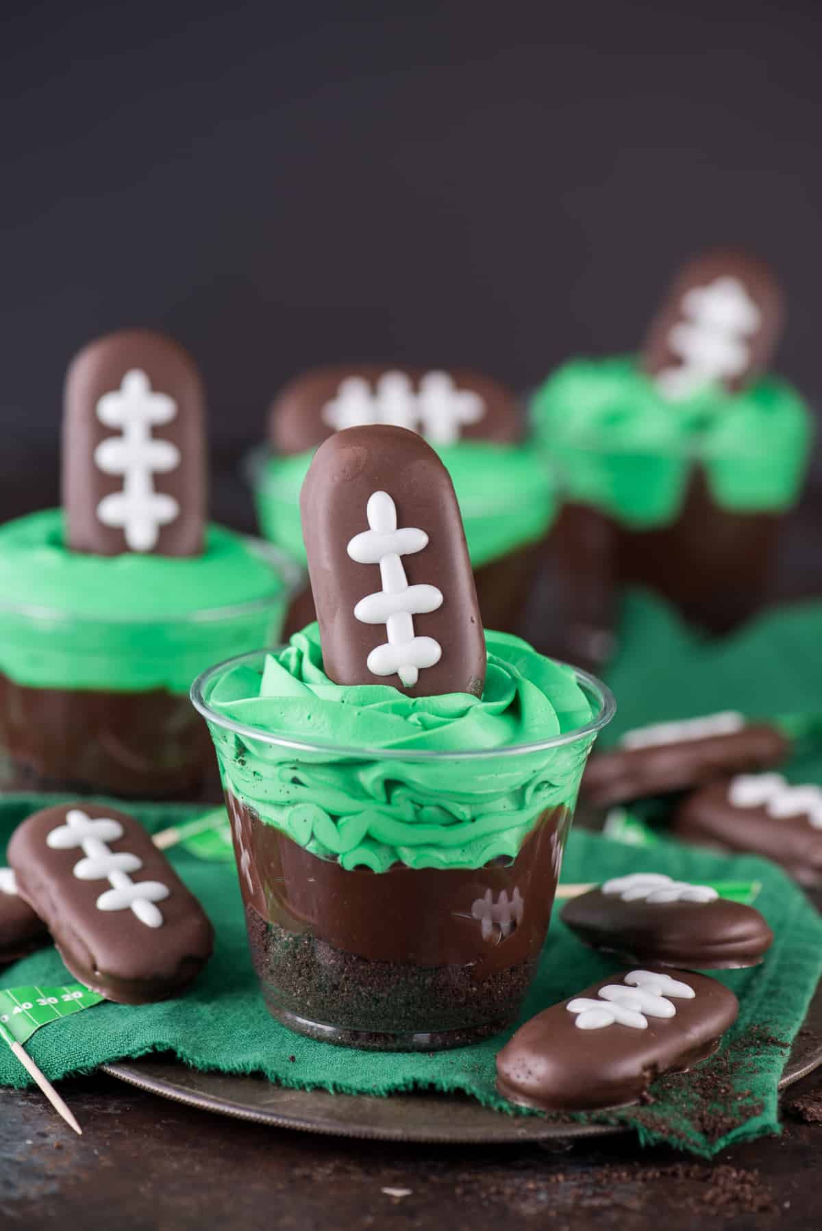 Football themed dirt cups - a fun football dessert to make for game day, super bowl, or a football themed birthday party! We made these and substituted football sprinkles for the football cookie on top.