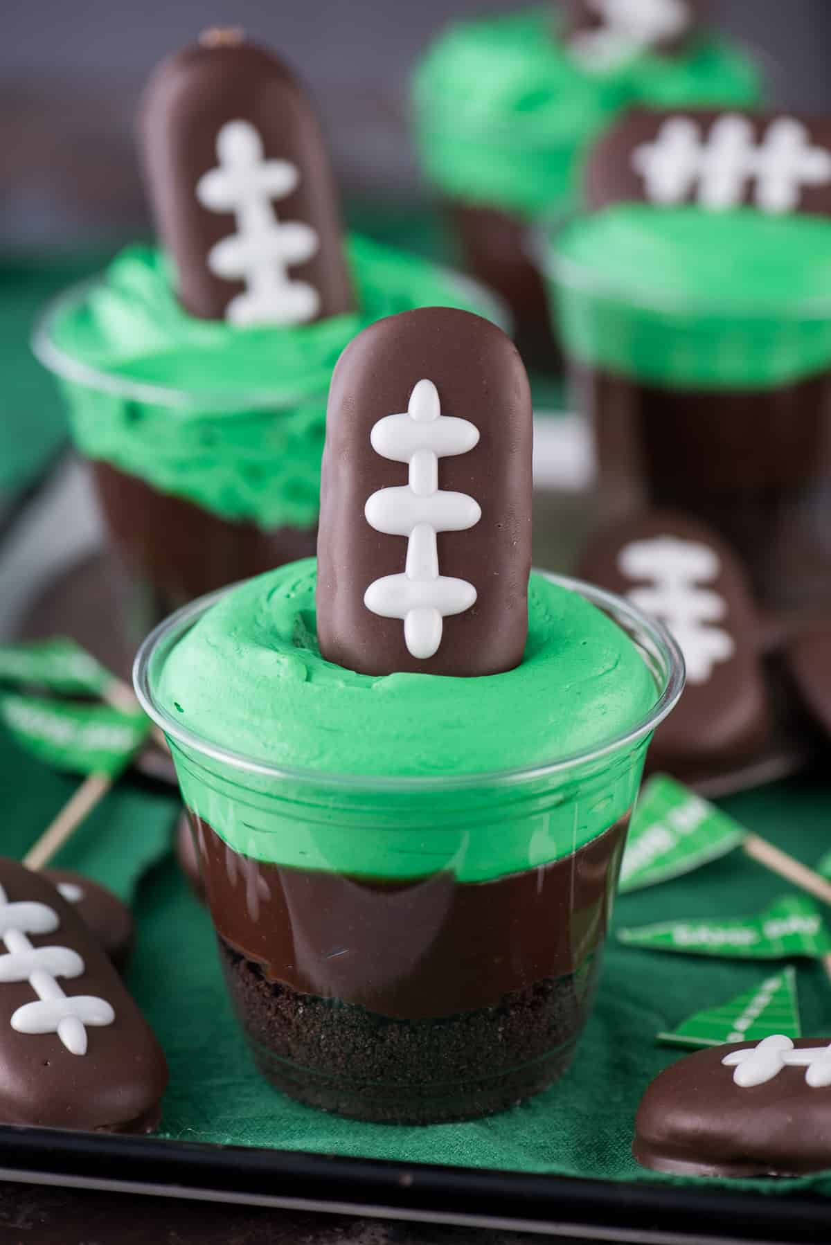 Football themed dirt cups - a fun football dessert to make for game day, super bowl, or a football themed birthday party! We made these and substituted football sprinkles for the football cookie on top.