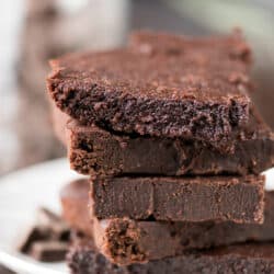 Five homemade healthier fudgy brownies on a white serving plate.