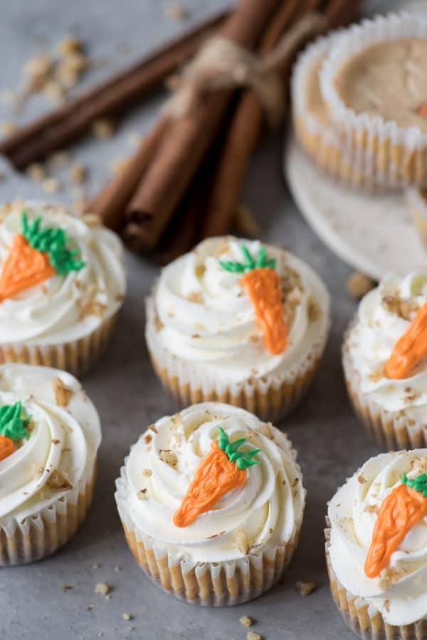 mini carrot cheesecakes with whipped cream frosting and orange carrot on top