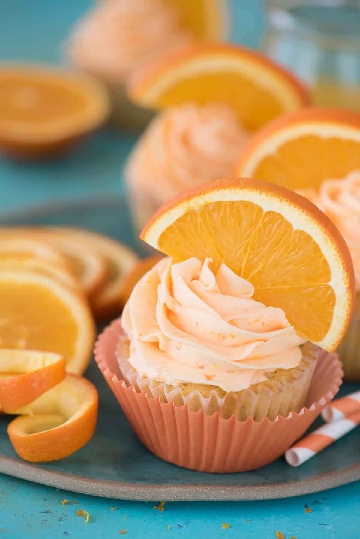 Orange Poppy Seed Cupcake with orange slice on blue background