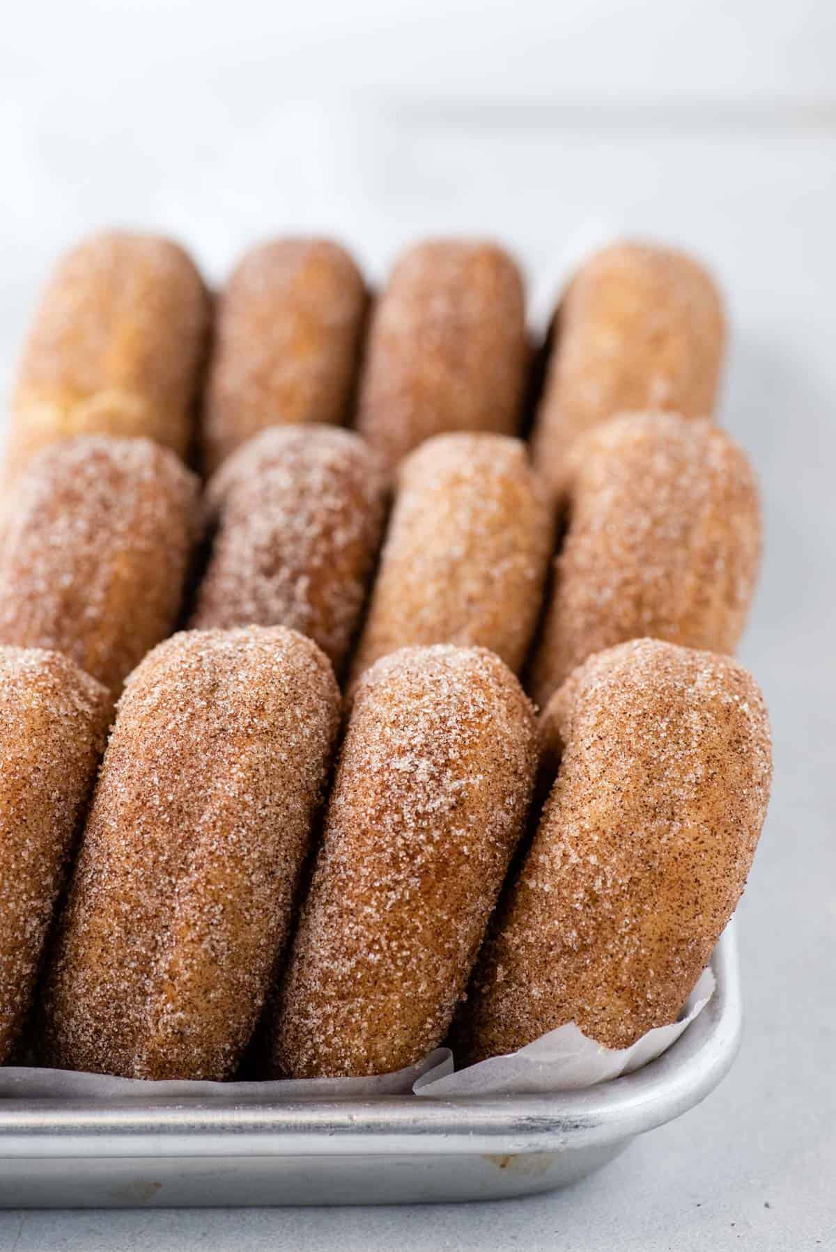 cinnamon sugar donuts arranged in lines on a pan