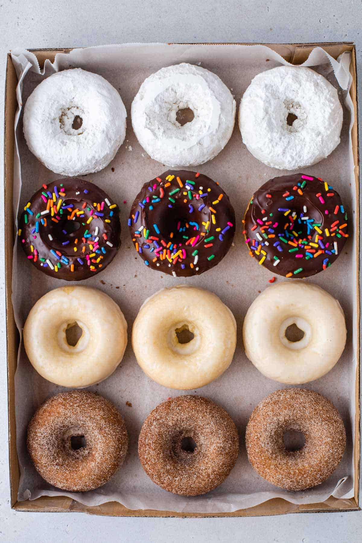 baked donuts with 4 different glazes arranged in donut box