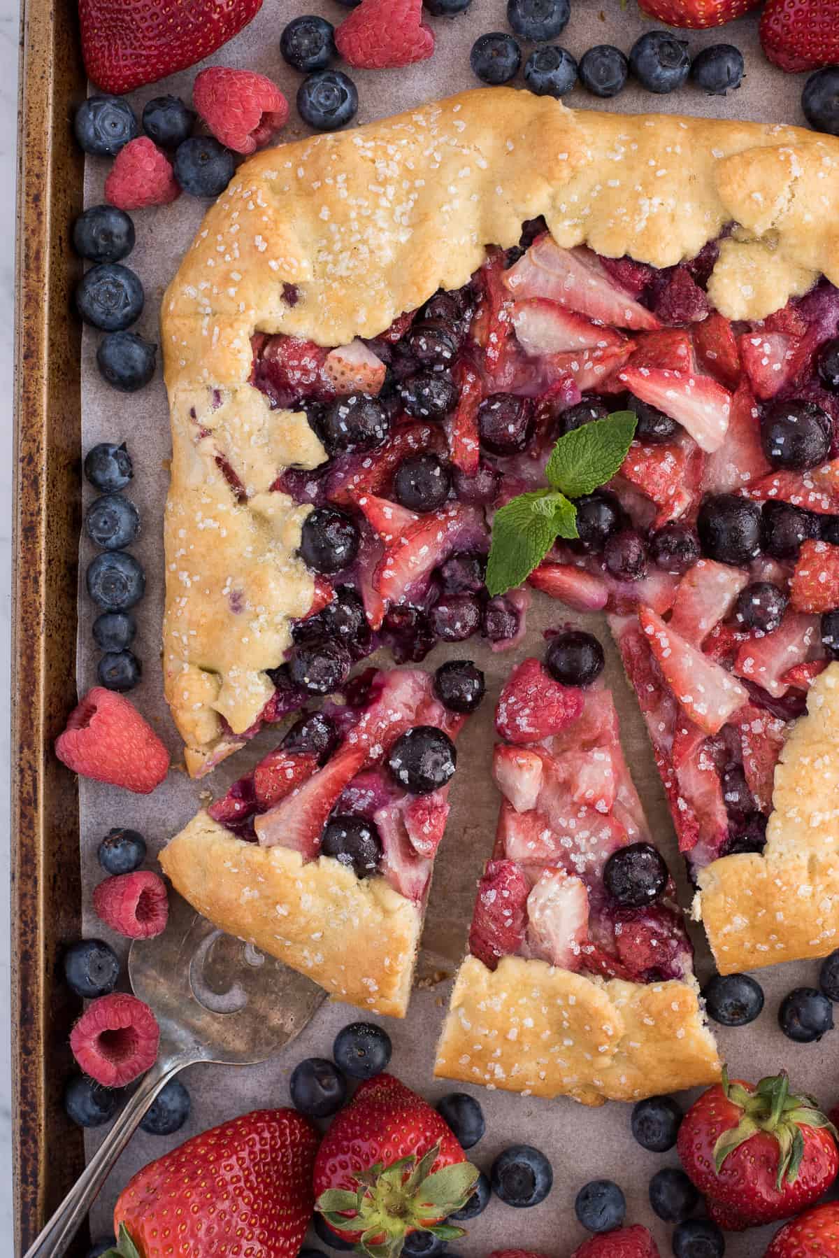mixed berry galette with strawberries and blueberries on metal baking sheet