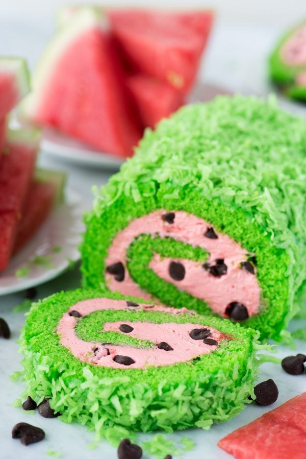 This summer watermelon cake roll would be so fun to include at a watermelon themed food party! green cake roll with pink filling and chocolate chips to look like a watermelon cake roll