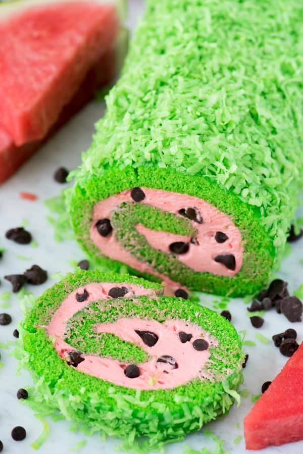 This summer watermelon cake roll would be so fun to include at a watermelon themed food party! green cake roll with pink filling and chocolate chips to look like a watermelon cake roll