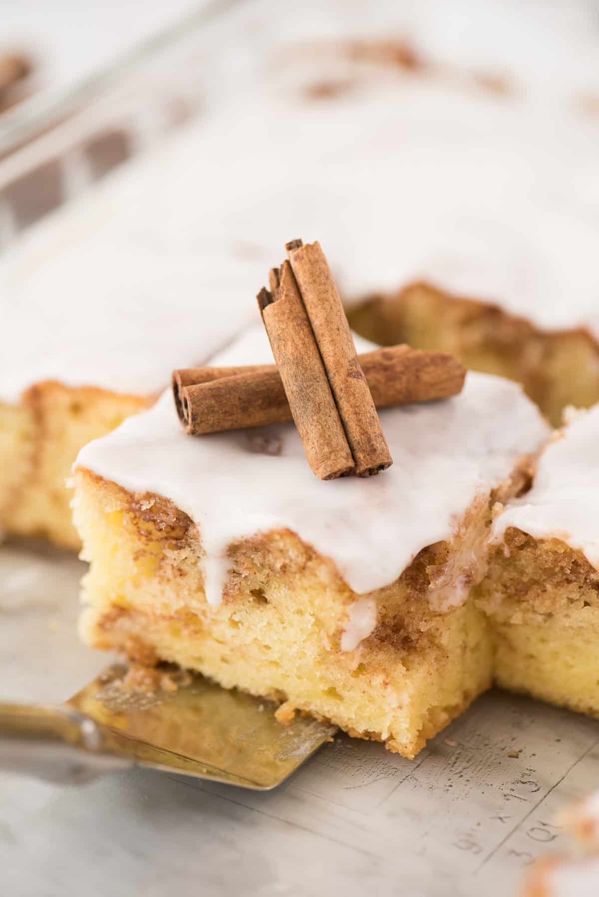 Removing a square of honey bun cake from the pan