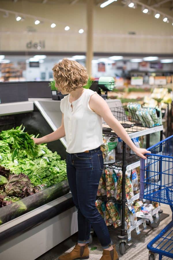 woman shopping for spinach in a grocery store 