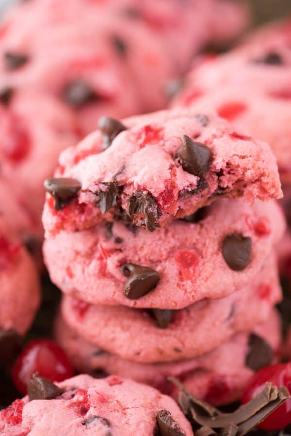 Thick & chewy maraschino cherry chocolate chip cookie recipe! Candied cherry cookie recipe. pink maraschino cherry chocolate chip cookies on baking sheet with cherries and chocolate chips