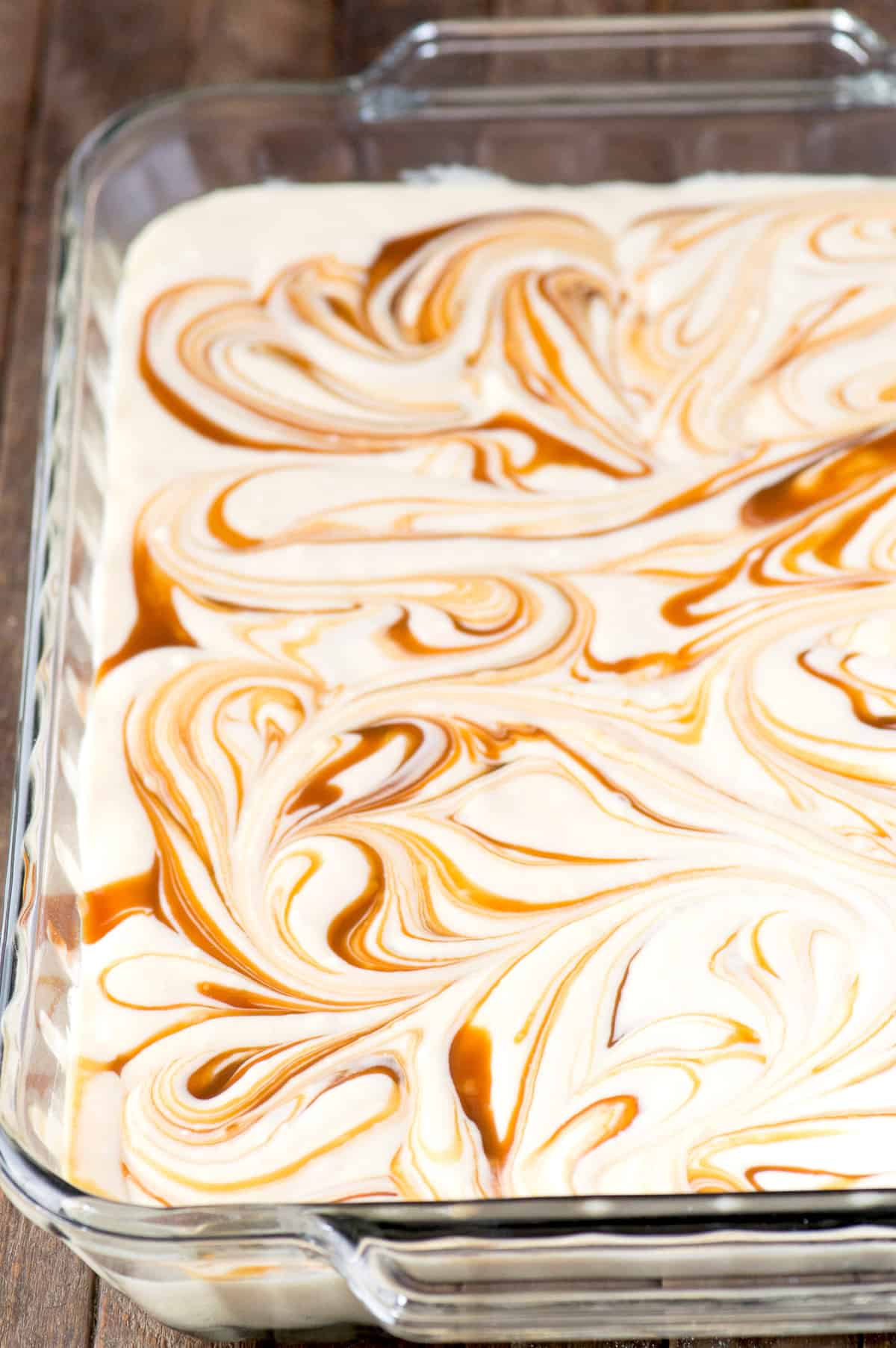 caramel cake with caramel swirled in batter in glass 9x13 inch pan
