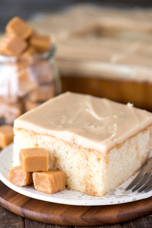 plak karamelcake op witte plaat op houten achtergrond