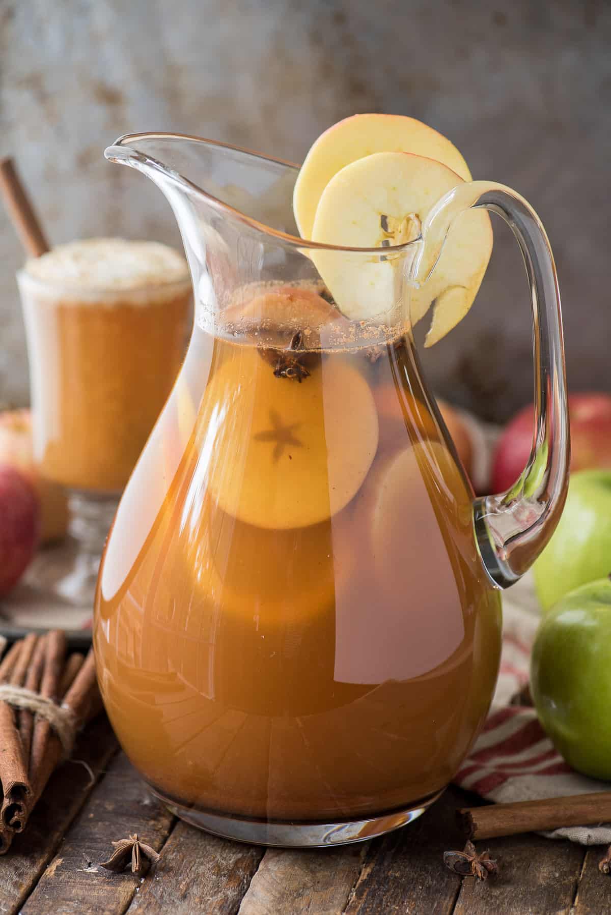 apple cider punch in glass pitcher with apple slices