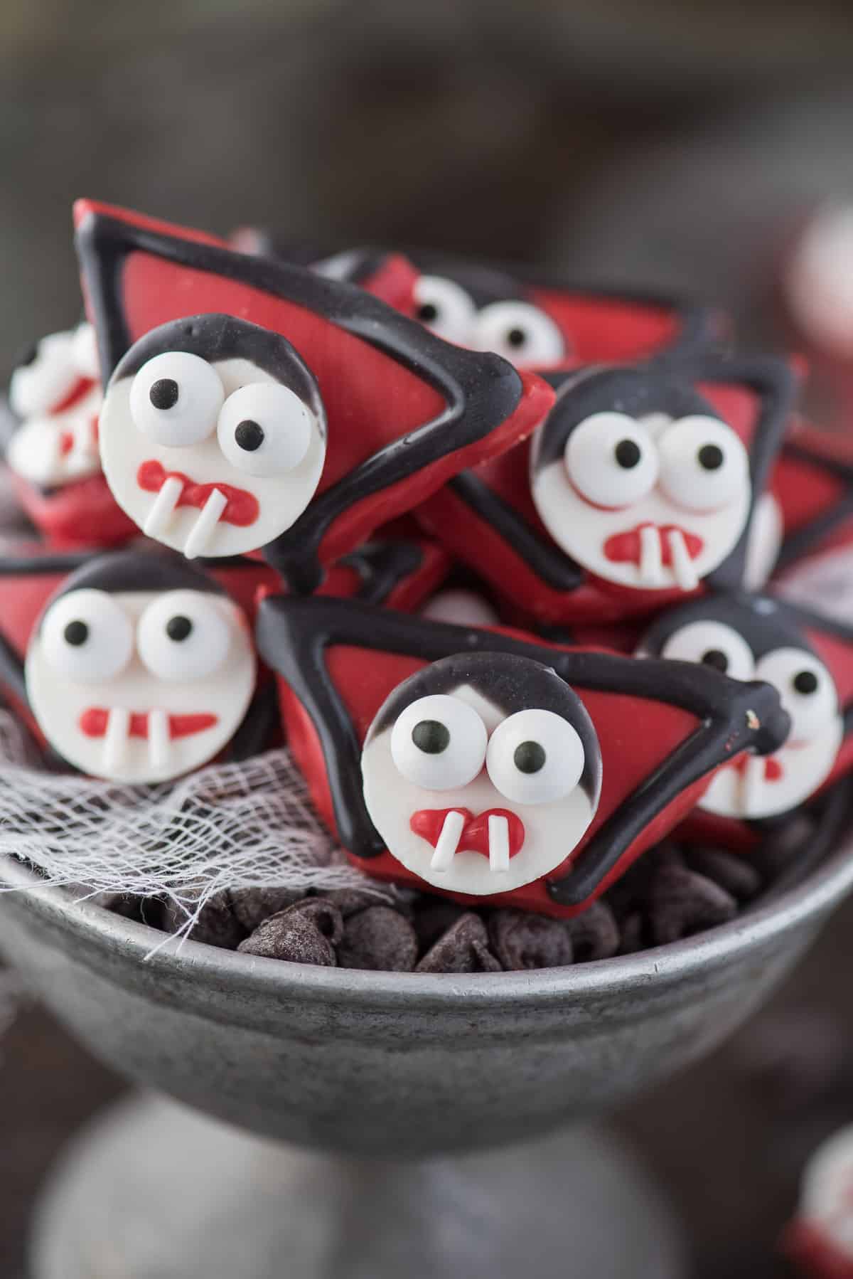 edible vampire treats made out of graham crackers and candy melts displayed in metal bowl