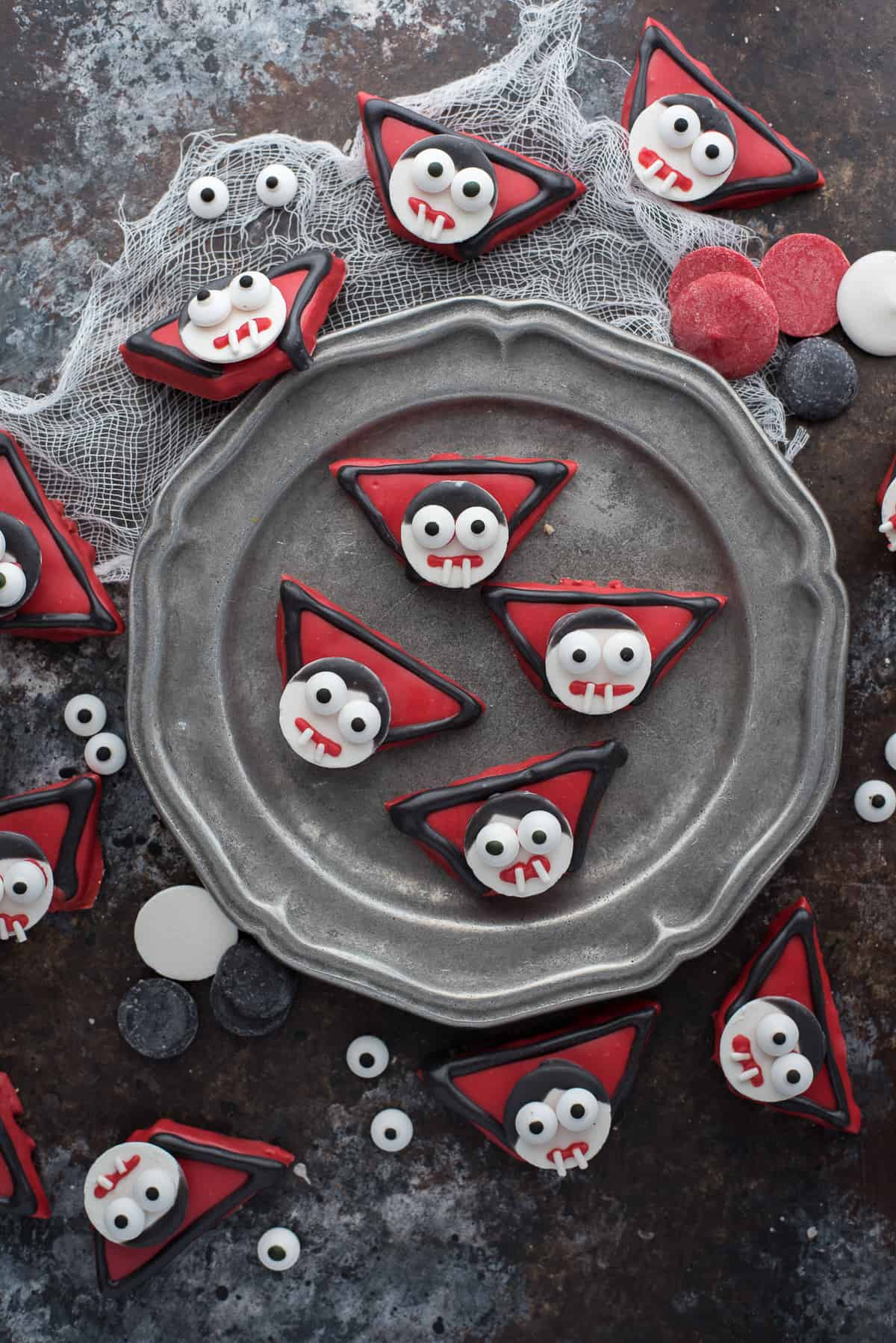 edible vampire treats made out of graham crackers and candy melts displayed on dark background