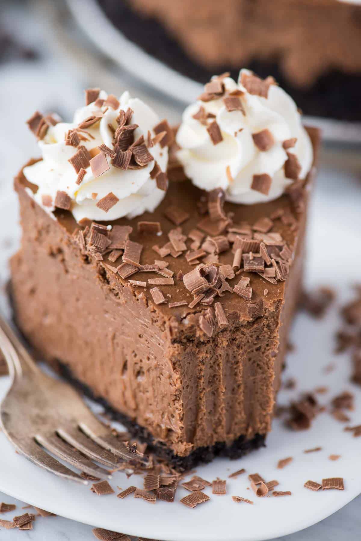 slice of chocolate cheesecake with chocolate shavings on white plate