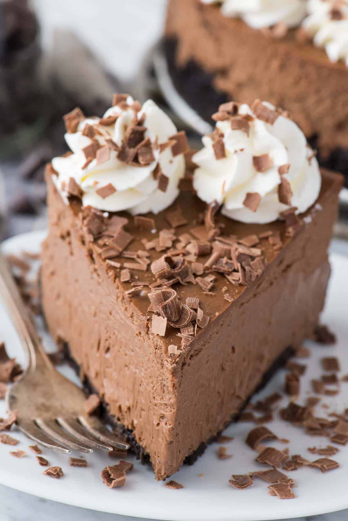 slice of chocolate cheesecake with chocolate shavings on white plate