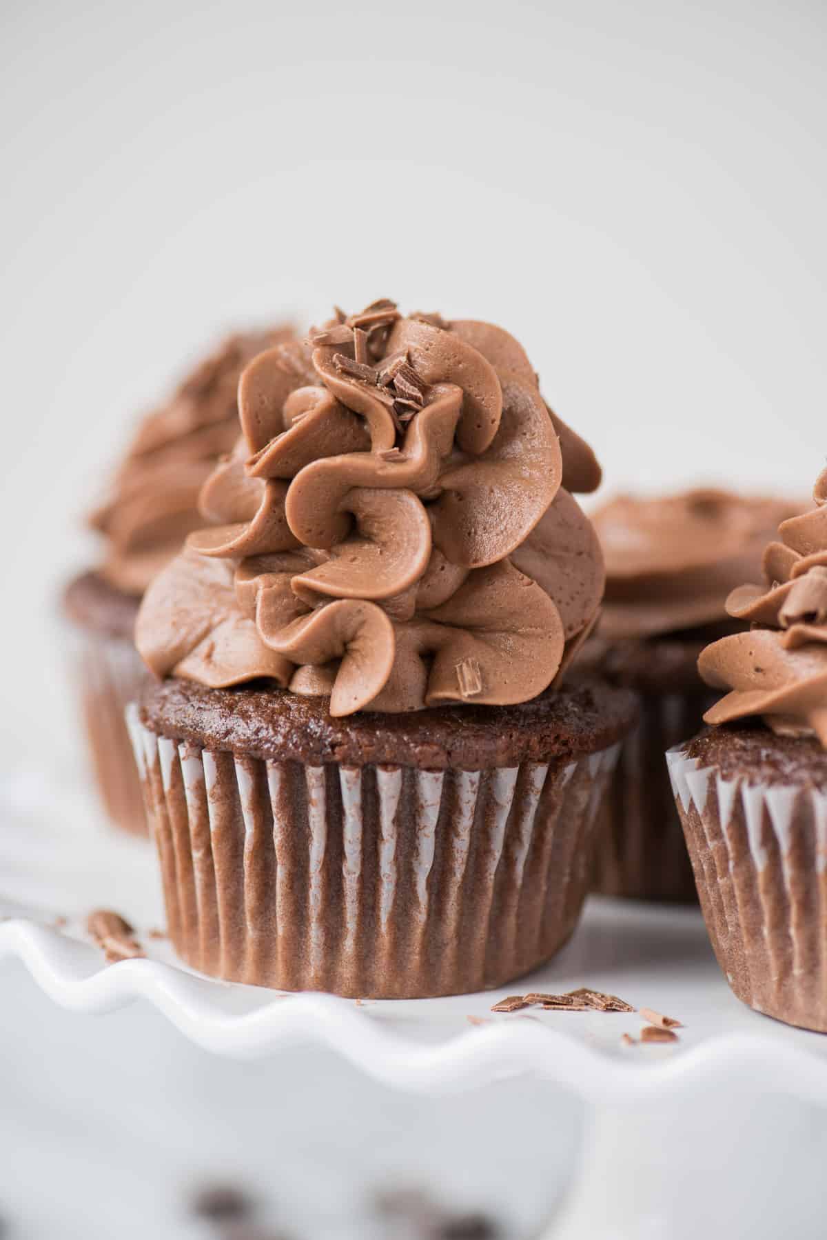 chocolate cupcakes with chocolate frosting on white plate