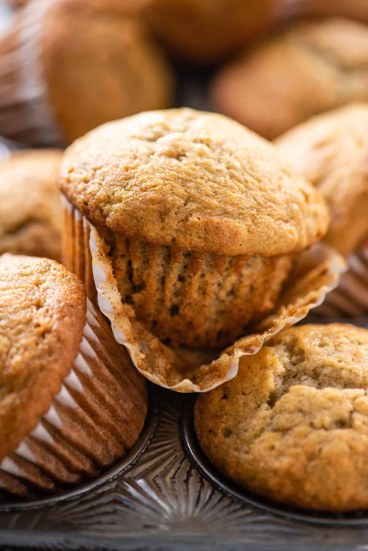 banana muffins stacked on top of each other in metal muffin pan