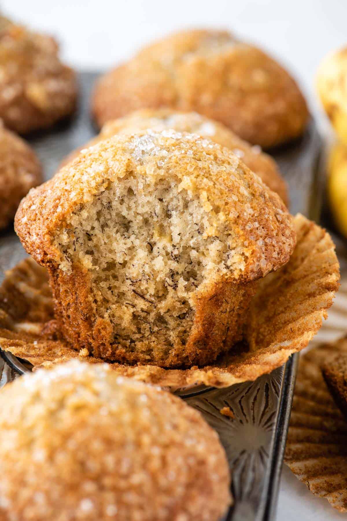 banana muffins in muffin pan with bite removed