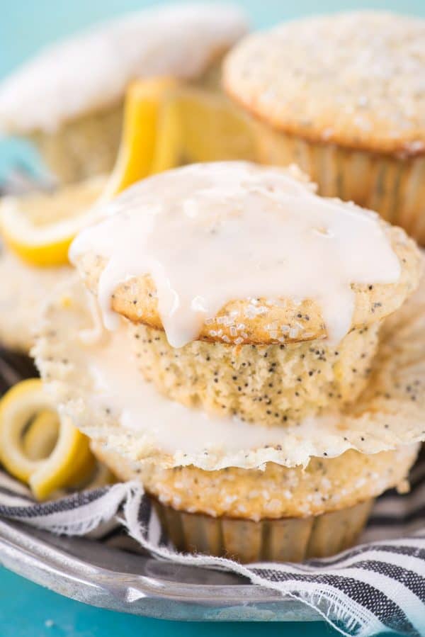 This is my favorite recipe for making bakery style lemon poppy seed muffins! Add course sugar to the tops or drizzle them with lemon glaze. These lemon muffins turn out so moist and flavorful with buttermilk and fresh lemons! Plus good tips on how to bake bakery style muffins! #lemonpoppyseedmuffins #muffins #lemonmuffins lemon poppy seed muffin with lemon glaze drizzled on top
