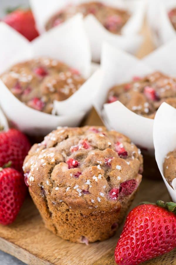 Use those ripe bananas and make fresh strawberry banana muffins. These strawberry muffins are dairy free and have been tested with gluten free flour with AMAZING results! You can also use frozen bananas and frozen strawberries to make these muffins. strawberry banana muffins in white parchment paper liners on wooden background