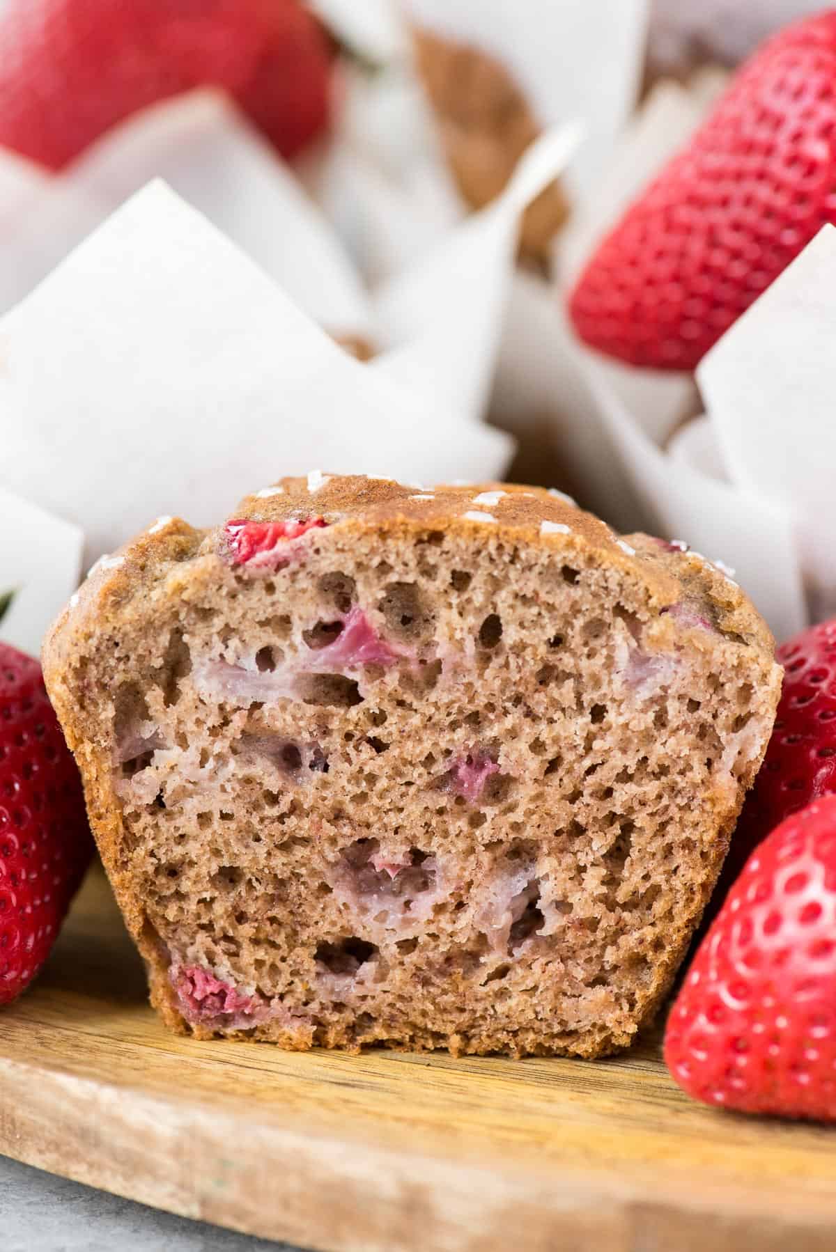 strawberry banana muffin cut in half on wooden background
