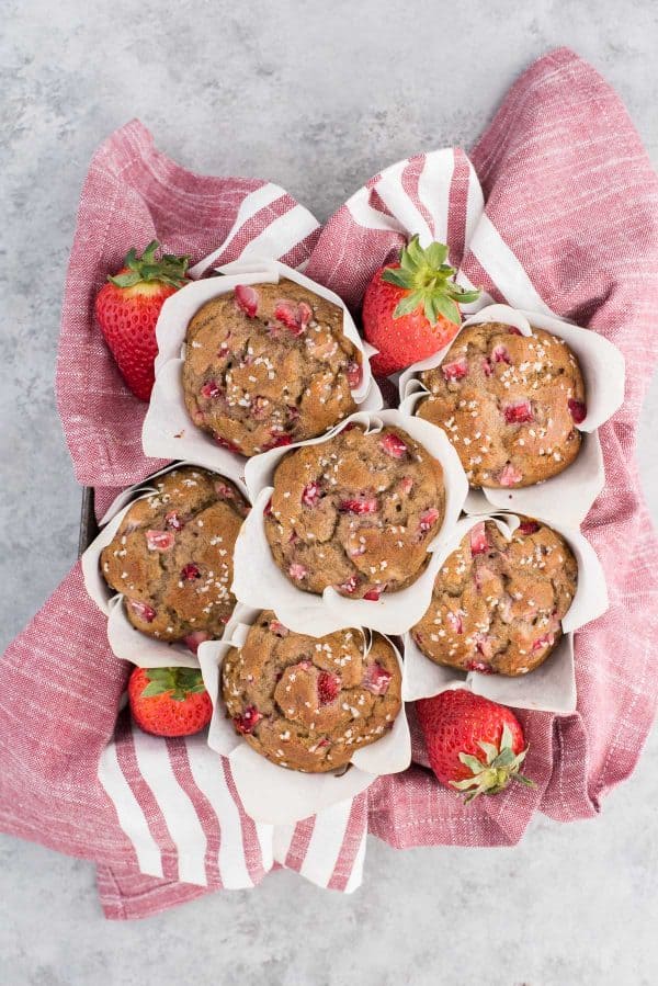 Use those ripe bananas and make fresh strawberry banana muffins. These strawberry muffins are dairy free and have been tested with gluten free flour with AMAZING results! You can also use frozen bananas and frozen strawberries to make these muffins. strawberry banana muffins in white parchment paper liners on red and white striped towel
