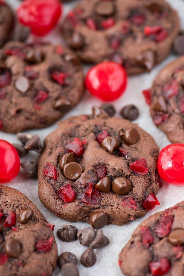 These black forest cookies are chocolate-y, chewy & soft and loaded with maraschino cherries and chocolate chips. Chocolate cherry cookies are easy to make, only 20 minutes from start to finish. Plus no chilling of the dough is needed! #blackforestcookies #cookies #cherrycookies #chocolatecookies black forest cookies with maraschino cherries and chocolate chips on white background