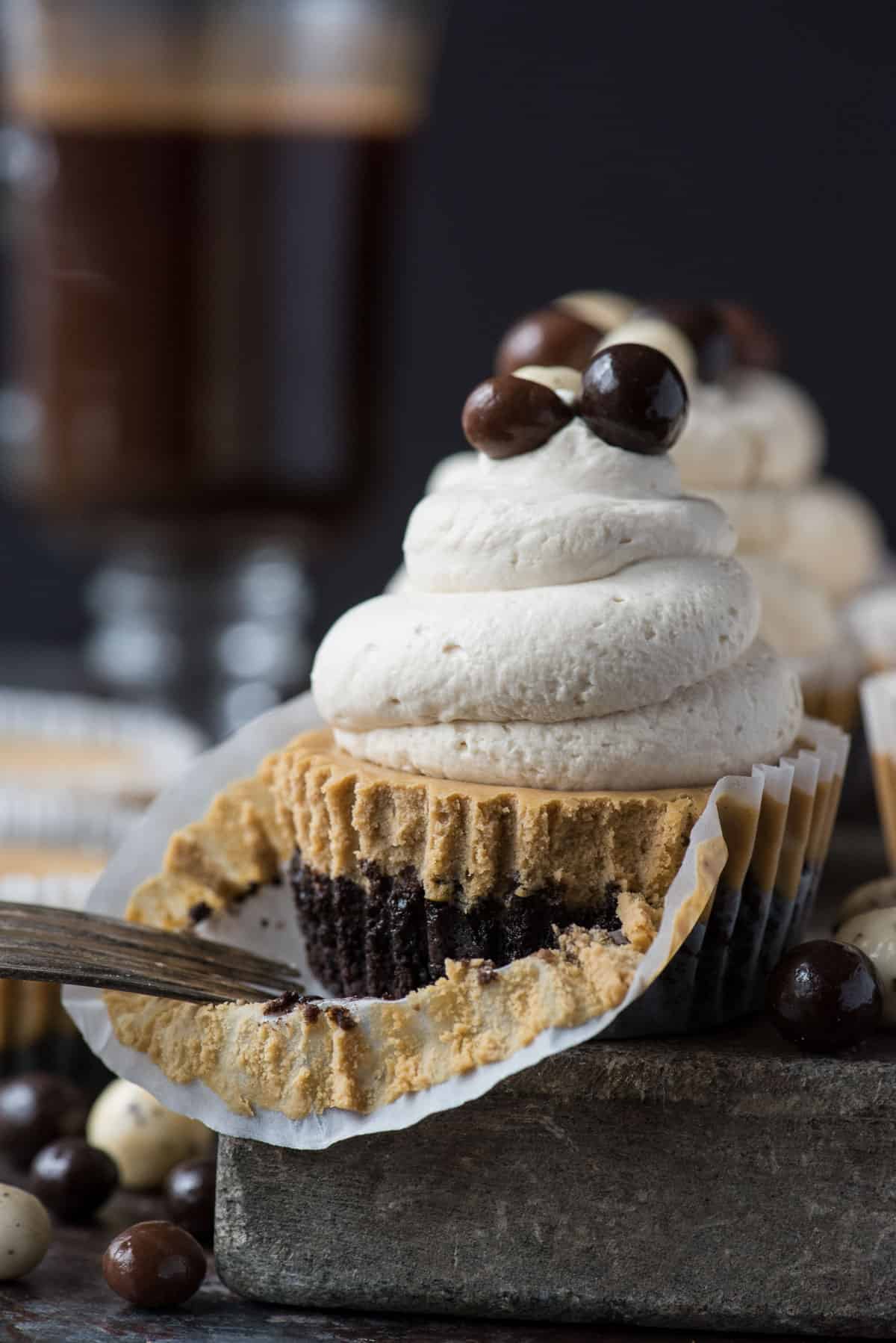 mini coffee cheesecake on stone slab with whipped cream and espresso beans