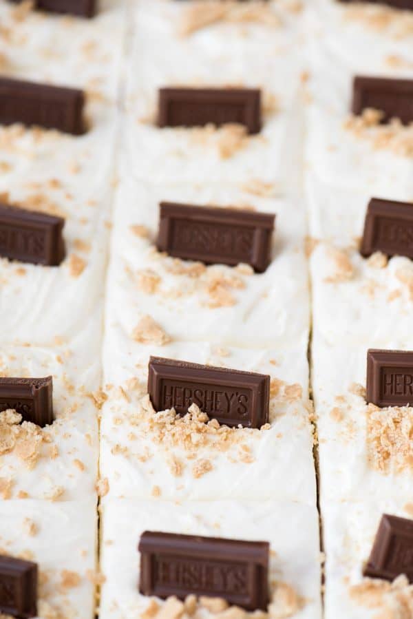 S’mores bars with marshmallow frosting and hershey’s chocolate bars in glass 9x13 inch pan
