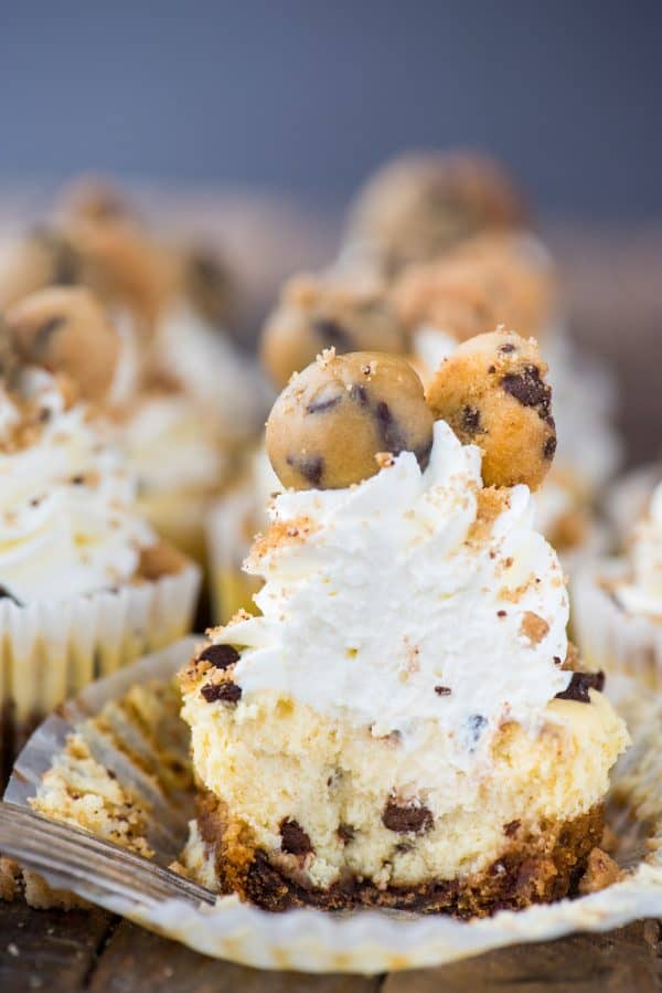 mini chocolate chip cookie dough cheesecake with bite removed on wood background