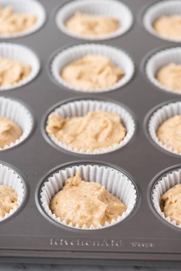 apple spice cupcake batter in metal muffin pan