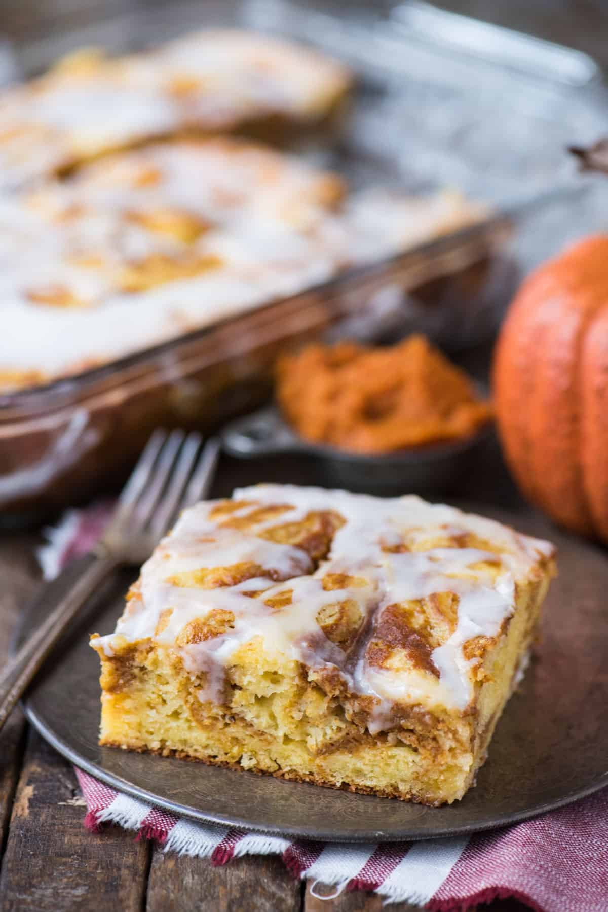 slice of easy pumpkin swirl cake with white icing on metal plate