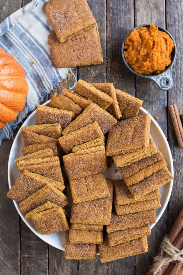 pumpkin graham crackers in a pile in a large white bowl on a wooden background