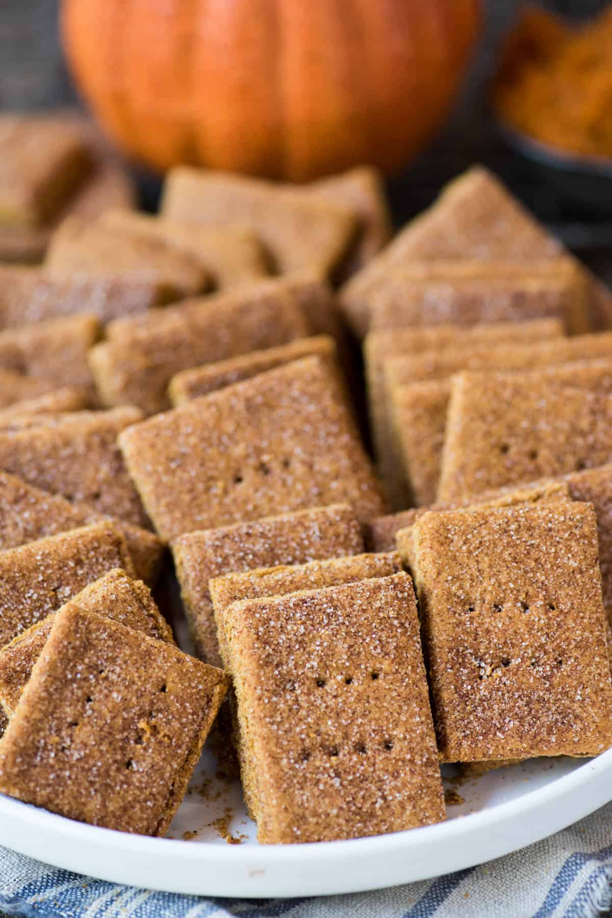 pumpkin graham crackers in a pile in a large white bowl on a wooden background
