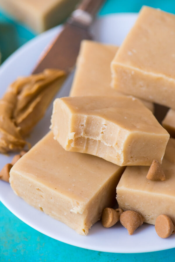pieces of peanut butter fudge on a white plate on a teal background