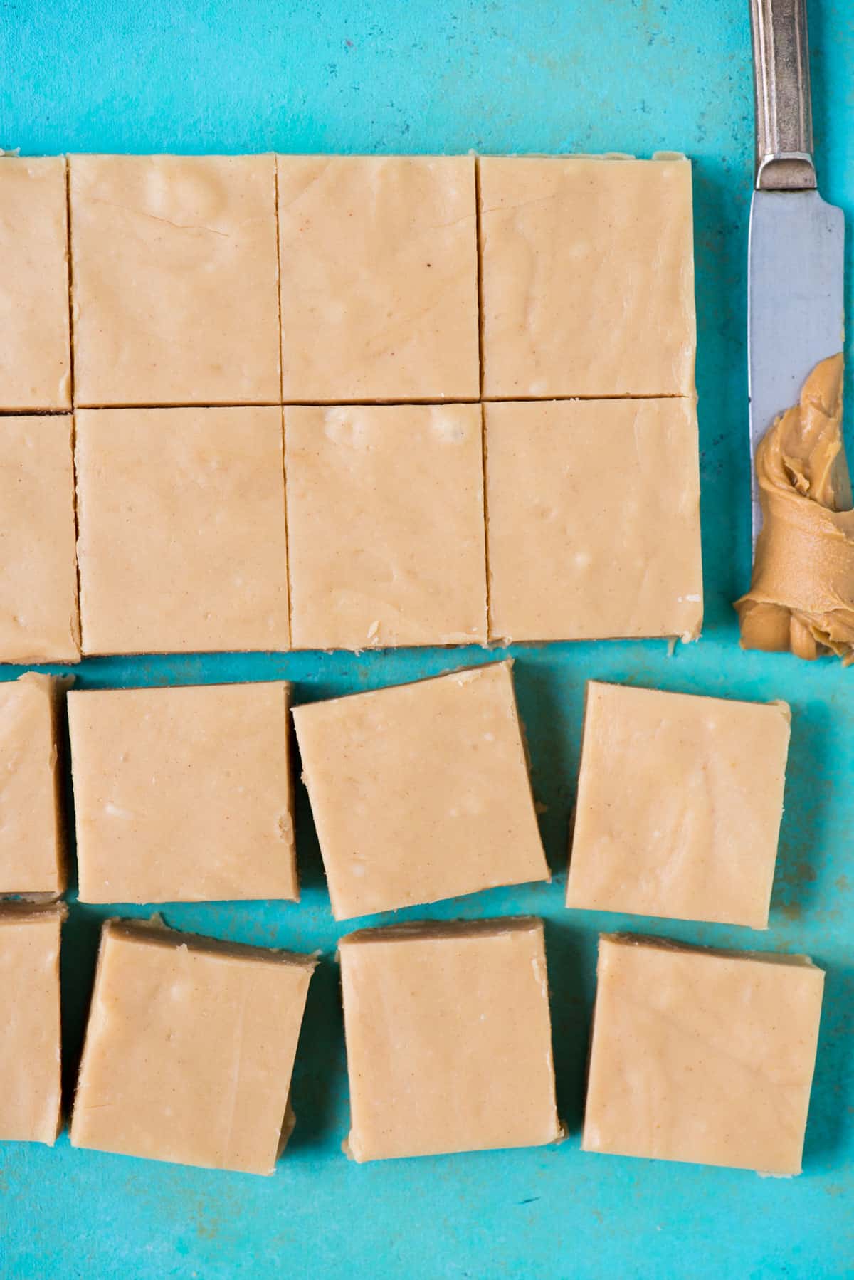 peanut butter fudge cut into pieces on a teal background