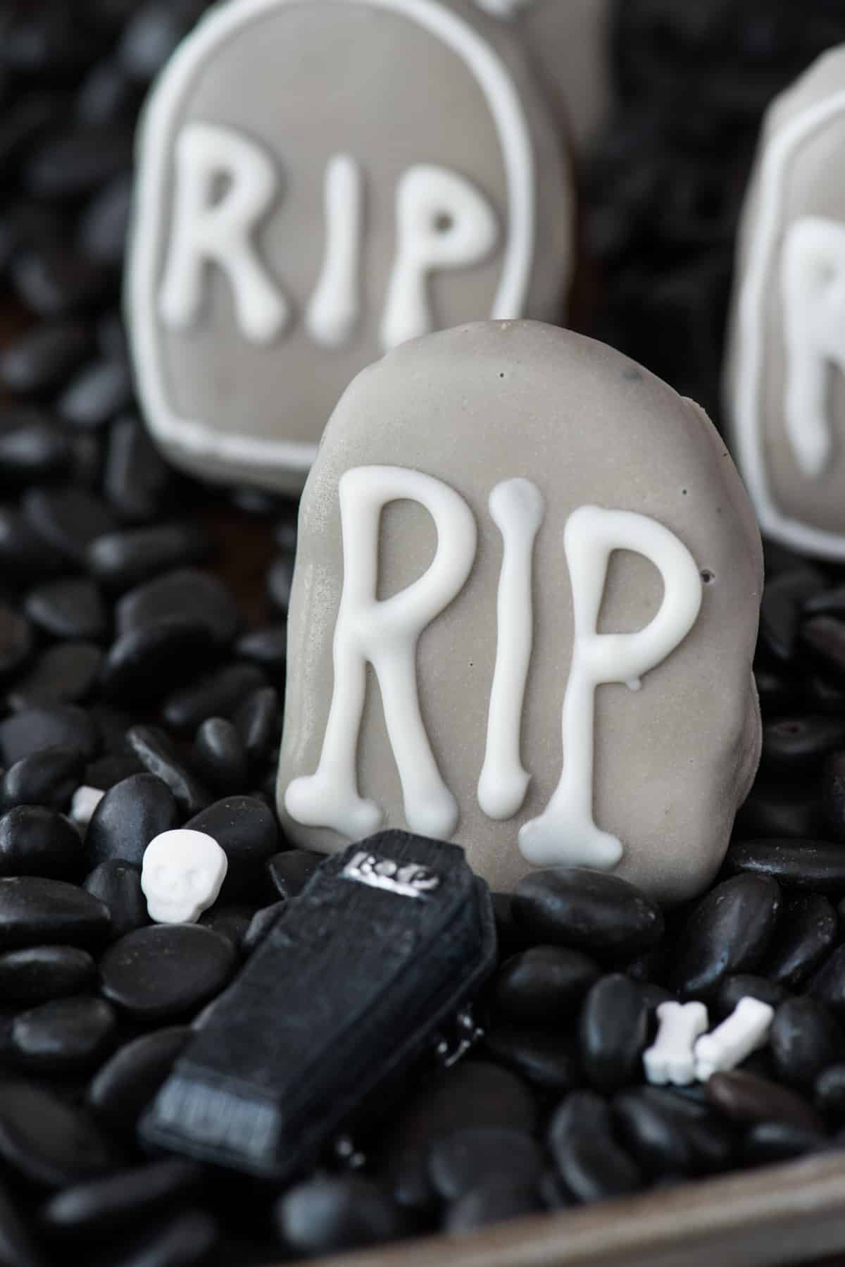 tombstone shape oreo ball in shallow pan surrounded with black rocks