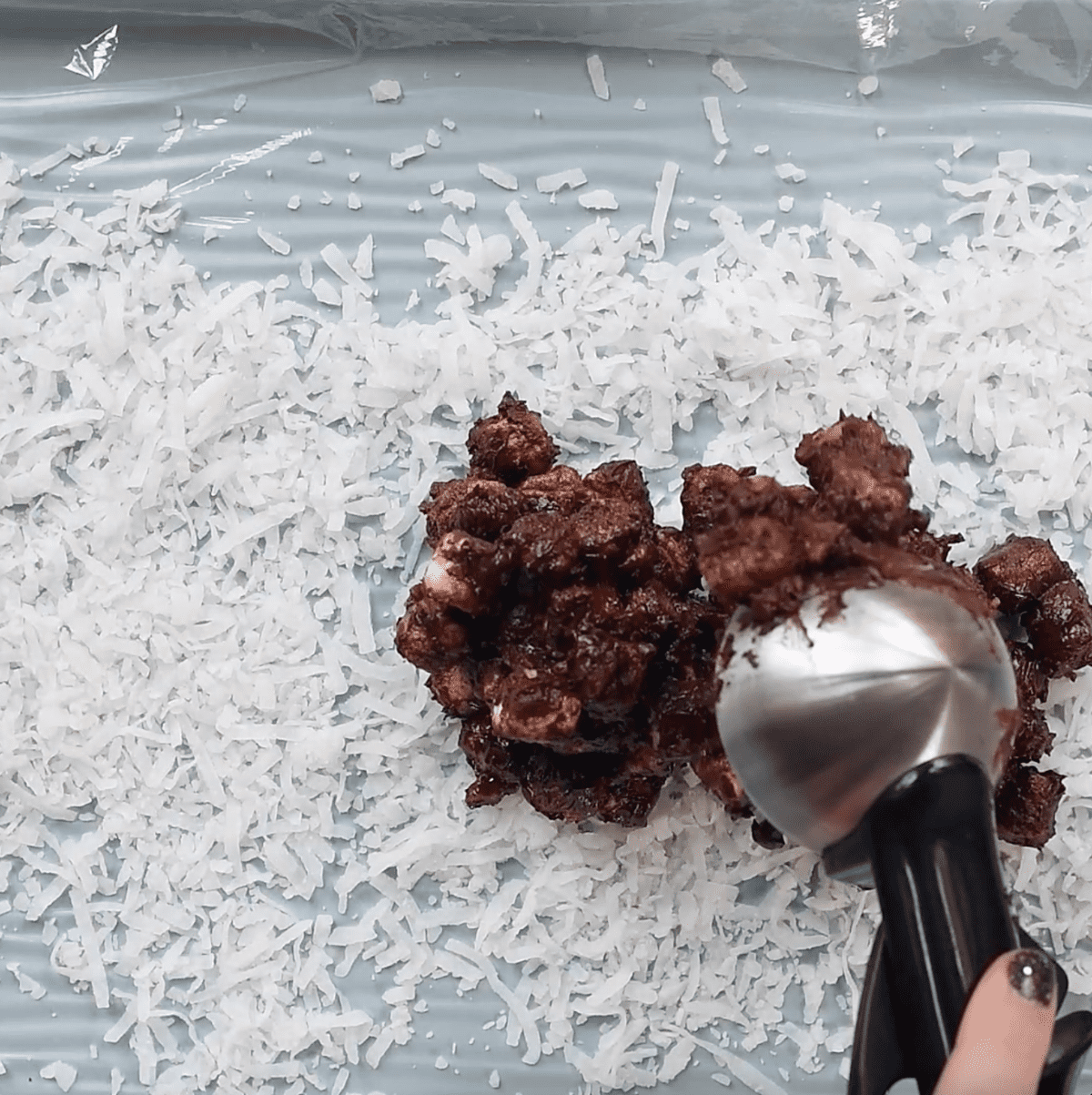 shredded coconut and chocolate marshmallows mixture spread over plastic wrap