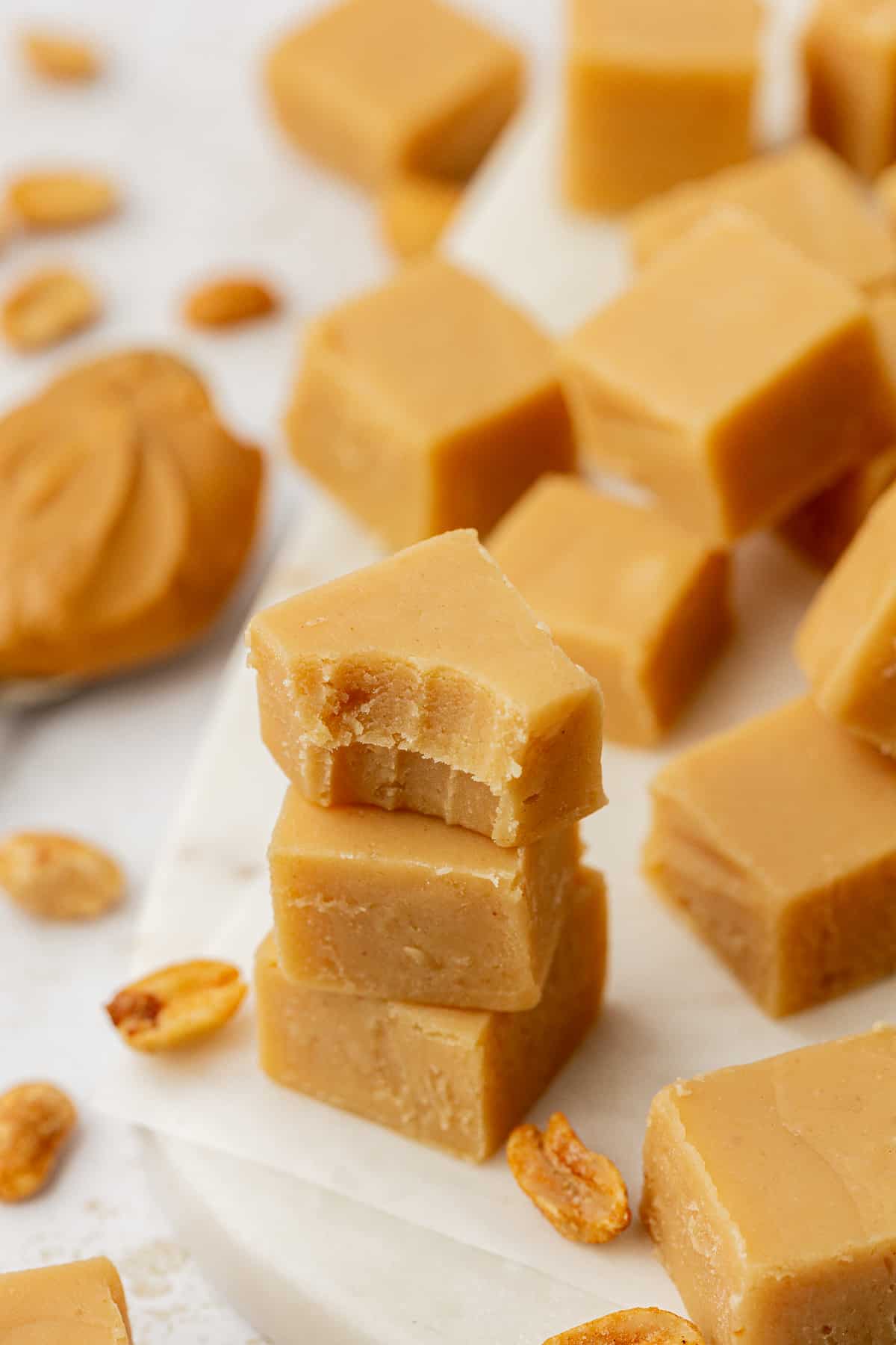 three pieces of peanut butter fudge stacked in a pile, one with bite removed