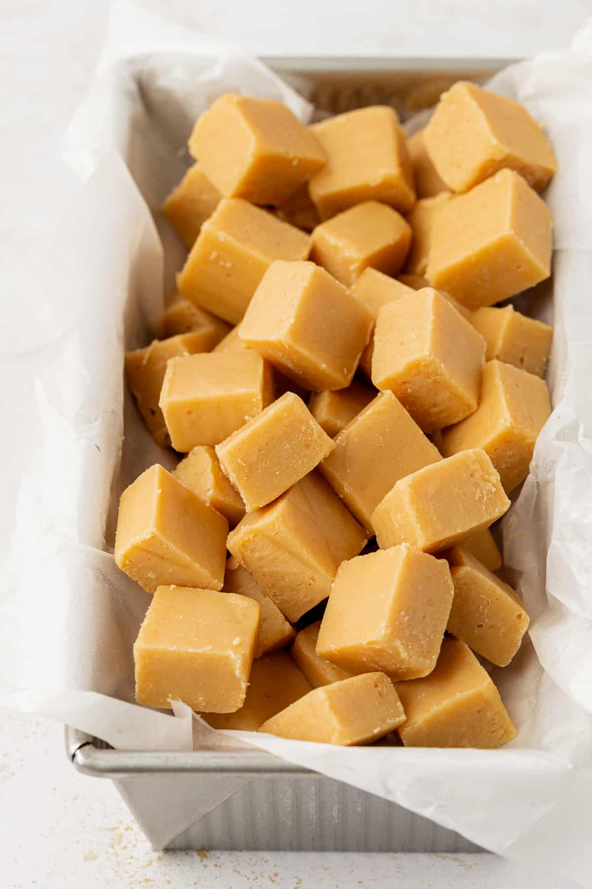 peanut butter fudge cut into small squares displayed in a loaf pan