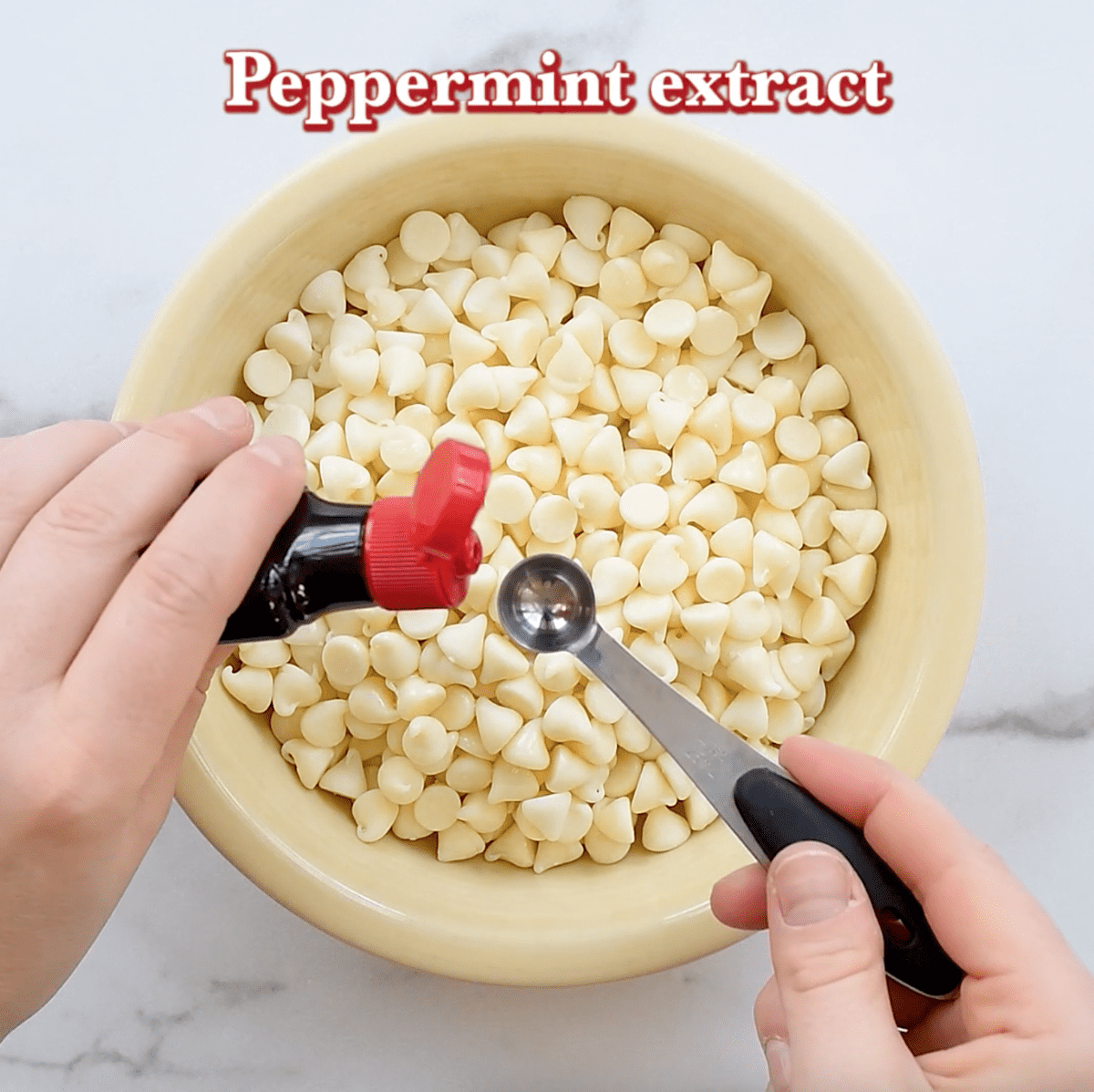 white chocolate chips with peppermint extract in cream bowl