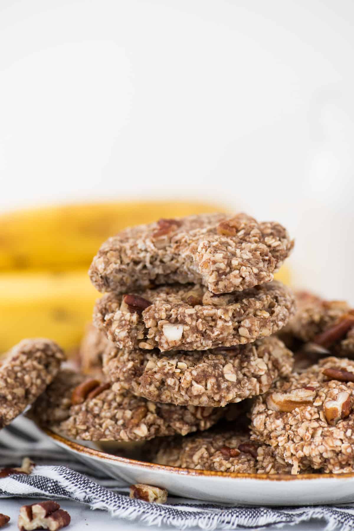 banana breakfast cookies on a white plate with striped towel underneath