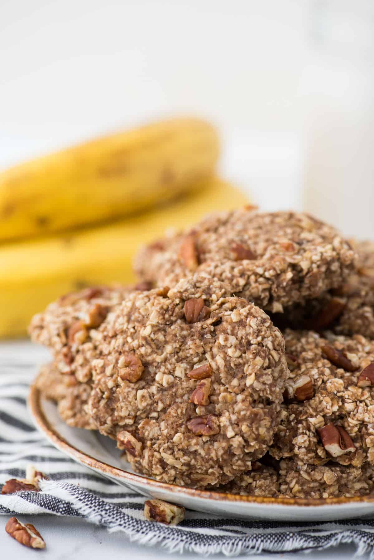 banana breakfast cookies on a white plate with striped towel underneath