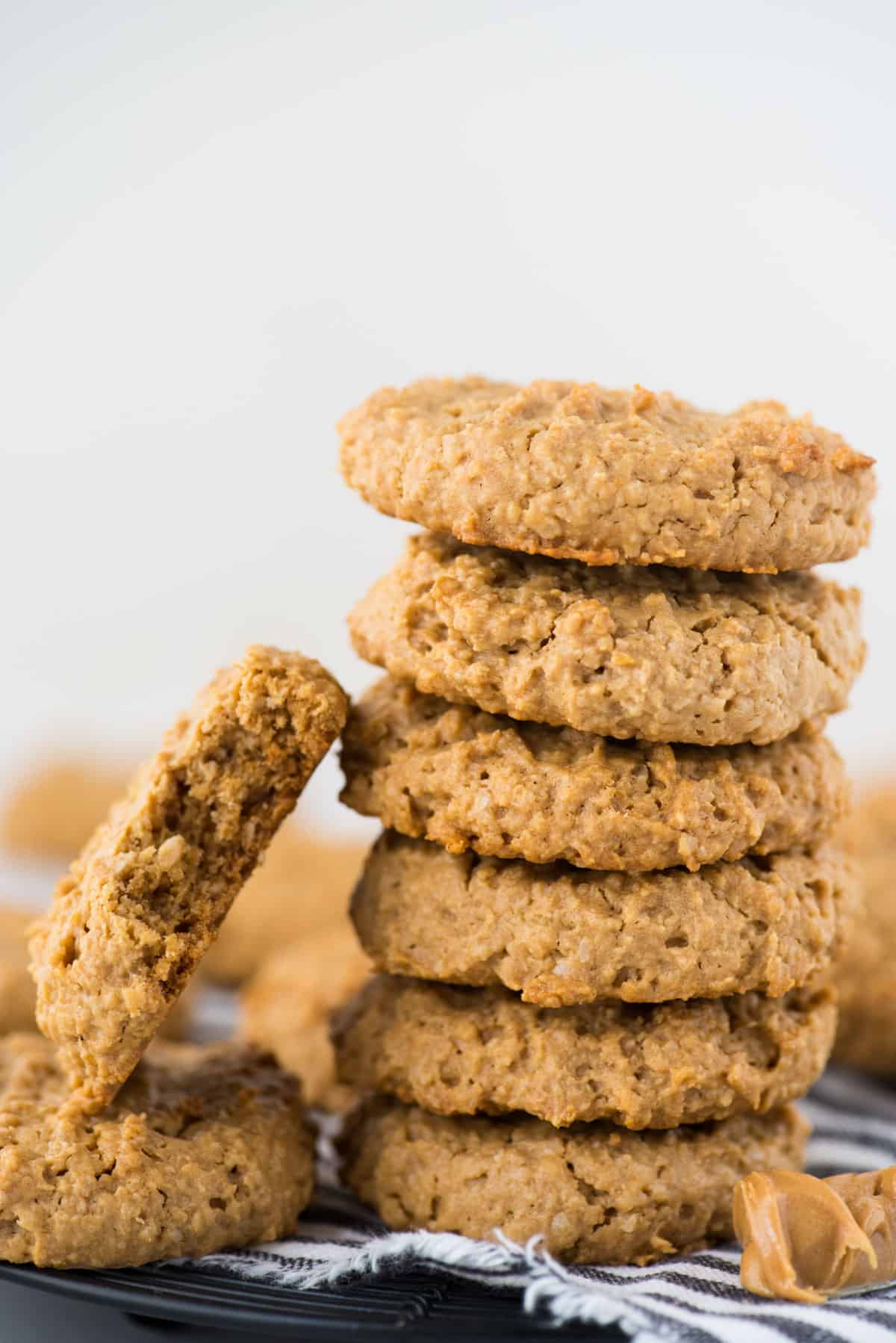 healthy peanut butter oatmeal cookies in a stack on white background