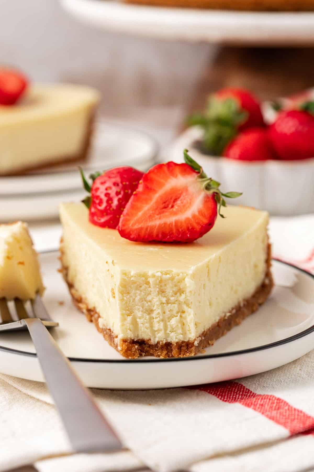 a slice of cheesecake on a plate with a bite removed